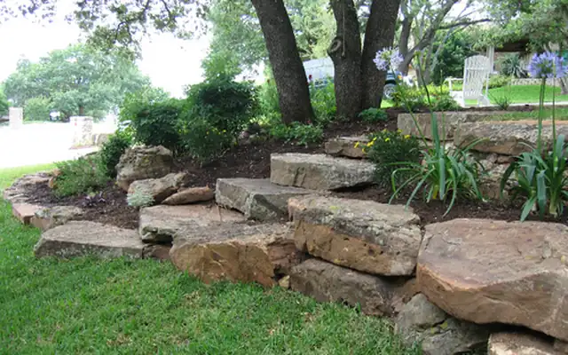 Large landscape boulders set as steps in a garden bed
