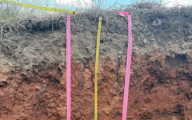 Soil profile with dark topsoil above red-brown subsoil