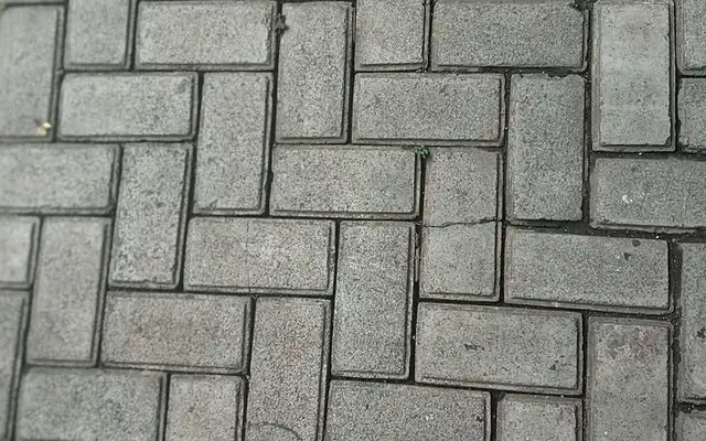 Gray concrete pavers laid in a herringbone pattern