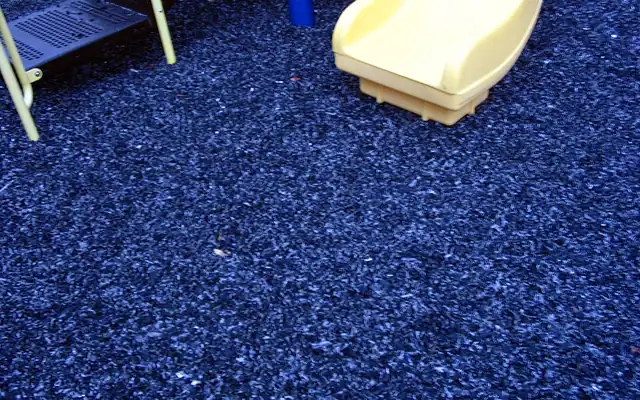 Blue rubber mulch under a playground slide