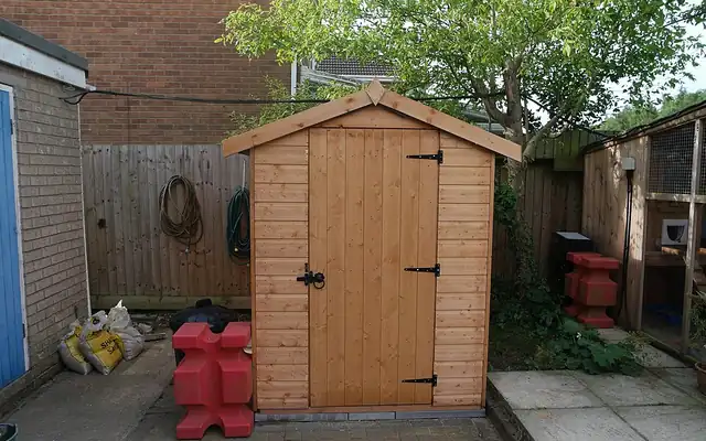 Wooden garden shed on a paved base